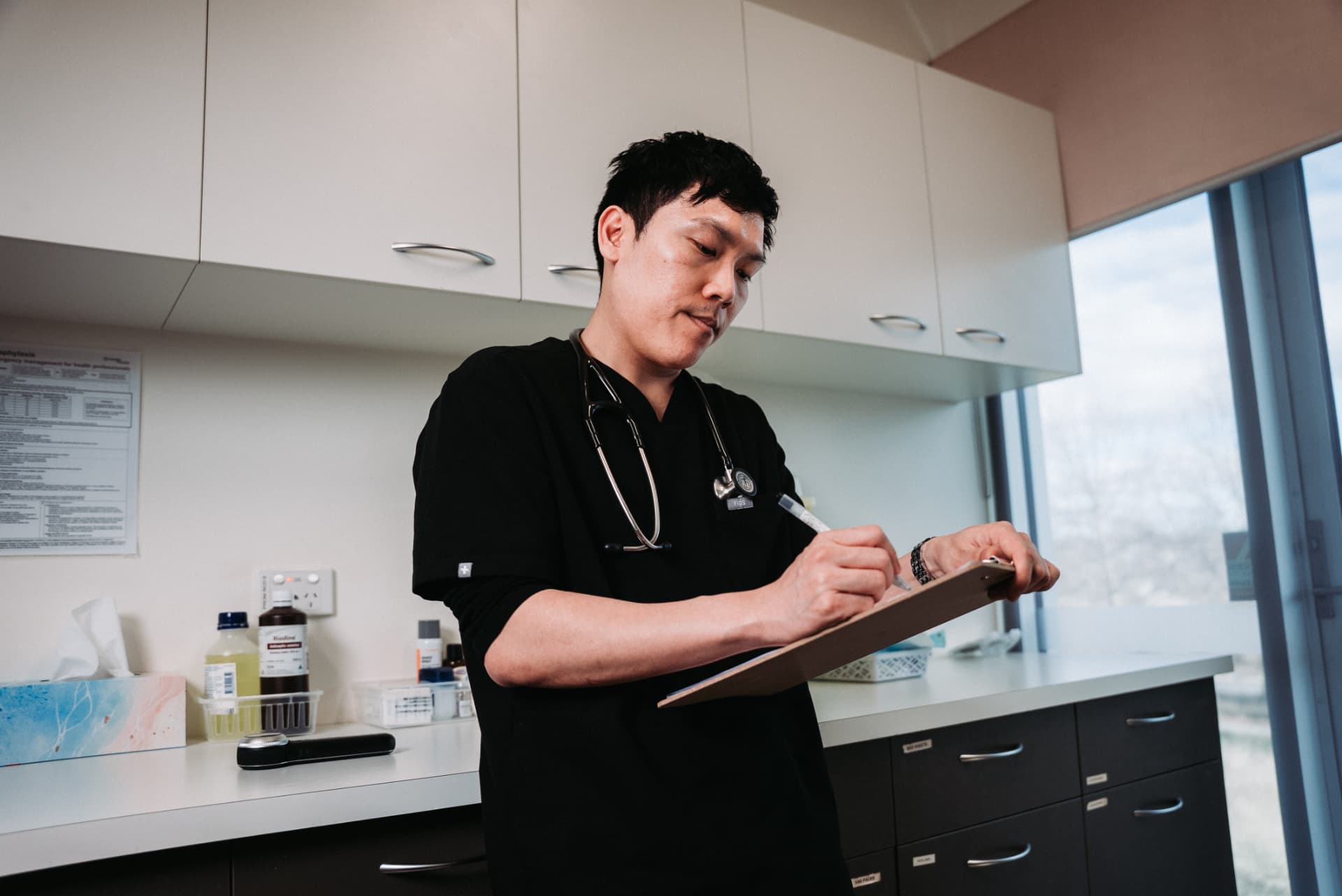 Dr William Fong reviewing patient notes in a clinical setting