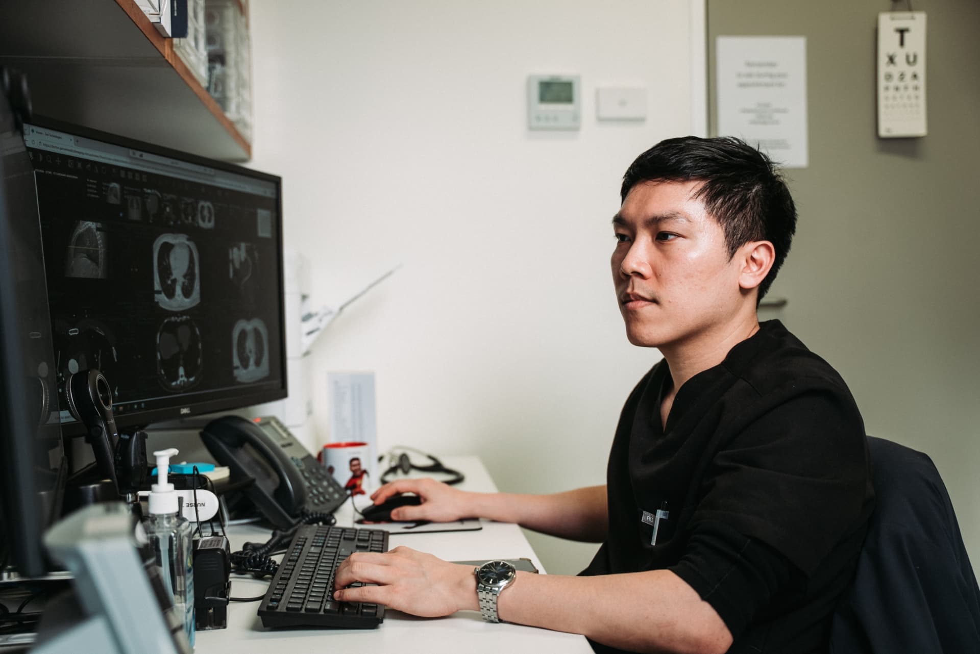 Dr William Fong reviewing a diagnostic scan at his desk