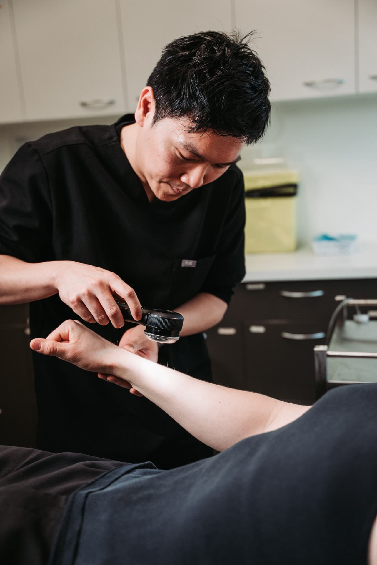 Dr William Fong performing a detailed skin check with a dermatoscope